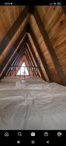 a white bed in a attic with a window at LOVA BUNGALOV in Ardeşen