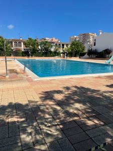 uma grande piscina azul numa cidade em Adosado con piscina y tenis em Benicàssim