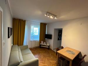 ズゴジェレツにあるCity Apartments - Emilii Budget Stayのリビングルーム(ソファ、テーブル付)
