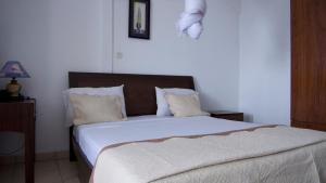 Mutsamudu的住宿－Océanis Hotel，卧室配有一张带白色床单和枕头的大床。