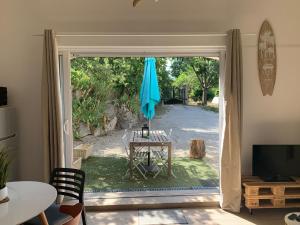una puerta abierta a un patio con mesa y sombrilla en Guest house proche Aix en Provence, en Simiane-Collongue