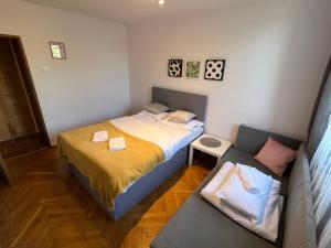 a small bedroom with a bed and a couch at City Apartments - Emilii Budget Stay in Zgorzelec