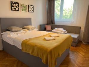 a bedroom with a bed with two towels on it at City Apartments - Emilii Budget Stay in Zgorzelec