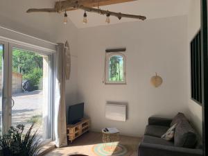 uma sala de estar com um sofá e uma televisão em Guest house proche Aix en Provence em Simiane-Collongue