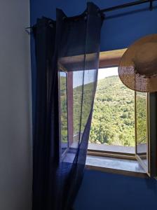 una ventana en una habitación con una pared azul en Le DueLamie, en Sessa Cilento