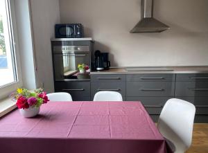 een keuken met een tafel met een paars tafelkleed bij Allgäulodge Memmingen in Memmingen