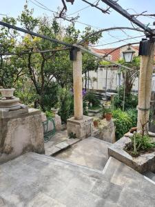 a garden with a pergola and some plants and trees at Rooms Ljubo in Dubrovnik