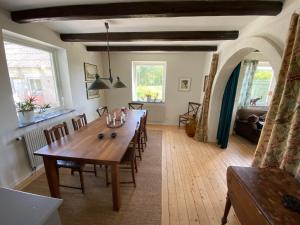 a dining room with a long wooden table and chairs at Beautiful view at unique farm in Höör