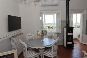 uma sala de jantar branca com uma mesa e cadeiras em Dimora Sotto la Rocca em San Miniato
