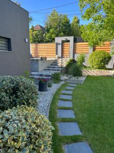 um jardim com um passadiço de pedra ao lado de uma casa em Bükkös Apartman em Szentendre