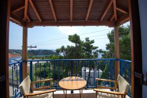 een patio met een tafel en stoelen op een balkon bij Kavos Apartments in Patitiri