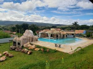 a house with a large swimming pool in a field at Chappada Hotel in Alto Paraíso de Goiás