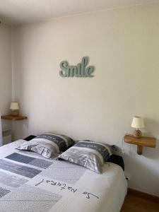 - une chambre dotée d'un lit avec un signe sourire sur le mur dans l'établissement Les Frahans, à Samoëns