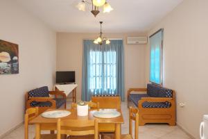 ein Wohnzimmer mit Tisch und Stühlen in der Unterkunft Kavos Apartments Alonissos in Patitiri