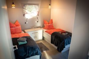 2 camas en una habitación con almohadas de color naranja en Ferien an der Eiche, en Schermbeck