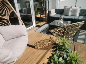 un soggiorno con una sedia in rattan e un divano di B&N Apartments a Mrągowo