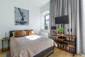 sypialnia z łóżkiem i telewizorem na stole w obiekcie Apartament Słoneczny - Młyn Maria - Art Apartments we Wrocławiu