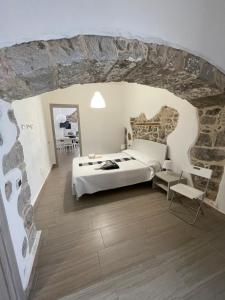 a bedroom with a bed and a stone wall at APPARTAMENTO S.ANTIOCO in SantʼAntìoco