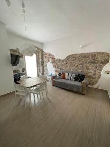 ein Wohnzimmer mit einem Sofa und einem Tisch in der Unterkunft APPARTAMENTO S.ANTIOCO in SantʼAntìoco