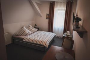 una piccola camera da letto con un letto e una finestra di Hotel Apartment Faraon a Rumburk Altre 37 foto