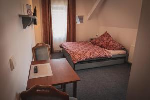 una piccola stanza con un letto e un tavolo di Hotel Apartment Faraon a Rumburk