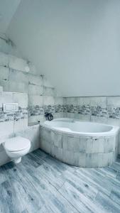 uma casa de banho branca com uma banheira e um WC em Ubytování Lednice em Lednice