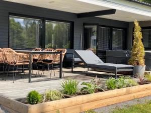 een terras met een tafel en stoelen bij Idyllic Villa Unikko With Jacuzzi And Sauna in Pori