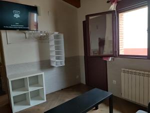 a room with a table and a shelf and a window at La Leñera in San Pascual