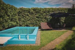 piscina blu con ombrellone e tavolo di Hotel Apartment Faraon a Rumburk
