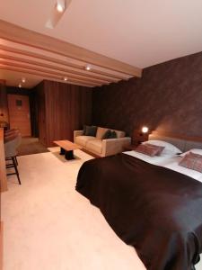 a bedroom with a large bed and a couch at Kopaonik011 Konaci&WoodSide Apartments in Kopaonik