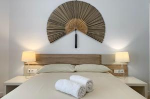 a large clock on the wall above a bed at Apartament galan1966 in L'Escala