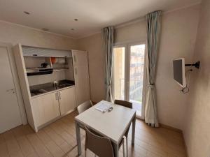 a small room with a table and a kitchen at Marina Beach Aparthotel in Rimini