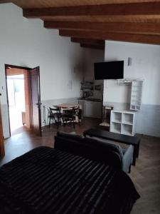 a living room with a couch and a table with a television at La Leñera in San Pascual