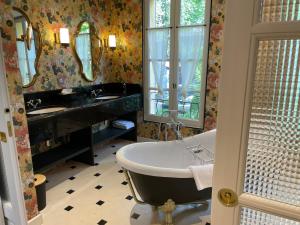 La salle de bains est pourvue d'une baignoire, d'un lavabo et d'un miroir. dans l'établissement Villa Amara, à Aix-en-Provence