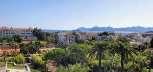 a view of a city with palm trees and buildings at Sea view Penthouse with terrace in Cannes