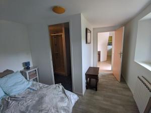 een slaapkamer met een bed en een tafel en een hal bij Appartement entier, vue sur rivière & cathédrale. in Plouguiel