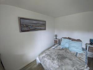 sypialnia z łóżkiem i zdjęciem na ścianie w obiekcie Appartement entier, vue sur rivière & cathédrale. w mieście Plouguiel