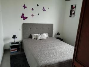 1 dormitorio con 1 cama con mariposas en la pared en au coeur des coteaux du Layon, en Le Champ-sur-Layon
