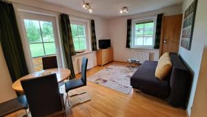 salon z kanapą i stołem w obiekcie Appartement Zirkl / Haus Gloria w mieście Haus im Ennstal