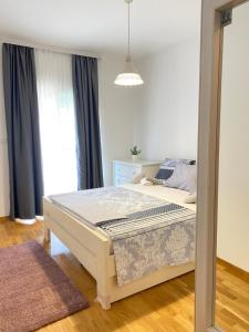 - une chambre avec un lit et une grande fenêtre dans l'établissement Apartman Vesna City 2. PG, à Podgorica