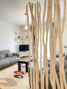 a living room with a tree branch wall at Apartman Vesna City 2. PG in Podgorica