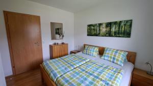 sypialnia z łóżkiem z kocem szachowym w obiekcie Appartement Zirkl / Haus Gloria w mieście Haus im Ennstal