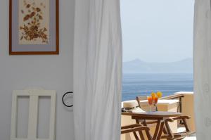 a table and chairs in a room with a view of the ocean at Arion Syros in Ermoupoli