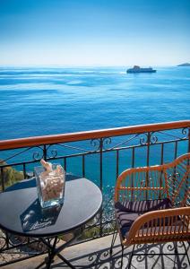 a table and chairs on a balcony overlooking the ocean at Arion Syros in Ermoupoli