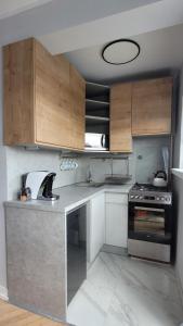 a kitchen with wooden cabinets and a stove at Lovely flat in heart of Wroclaw in Wrocław