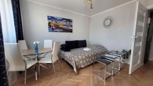 a living room with a table and a bed and a table and chairs at Lovely flat in heart of Wroclaw in Wrocław