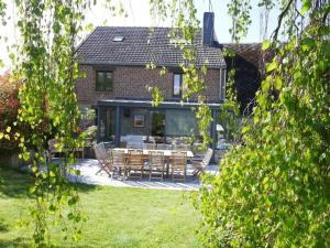 a house with a patio with a table and chairs at Gîte 7ici in Blaimont
