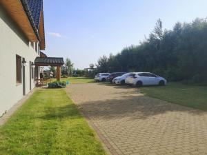 rząd zaparkowanych samochodów zaparkowanych obok budynku w obiekcie Pensjonat Ślepowron w mieście Międzywodzie