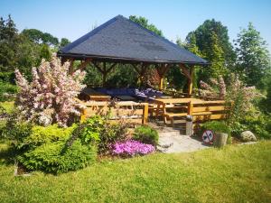 a wooden gazebo in a garden with flowers at Pensjonat Ślepowron in Międzywodzie