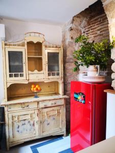 een keuken met een rode koelkast naast een bakstenen muur bij Cres B studio apartman in Cres